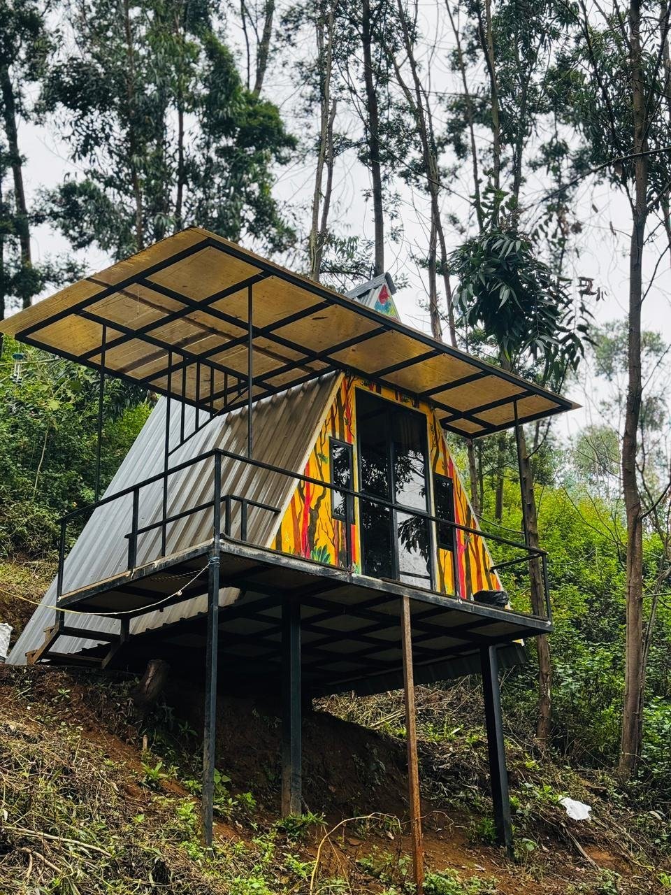 Painted A-frame hut on stilts at Mowgli Camp